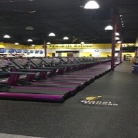 gym with yellow walls, black ceiling & floor with rows of purple and black treadmills by Dralynn Floor Covering Inc.